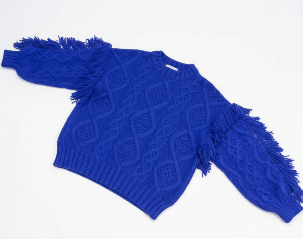 Blue sweater with fringe details on a white background