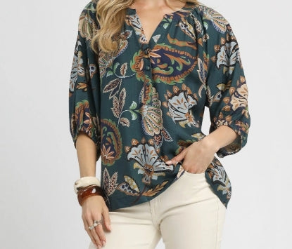 Woman wearing a patterned blouse with a plain background