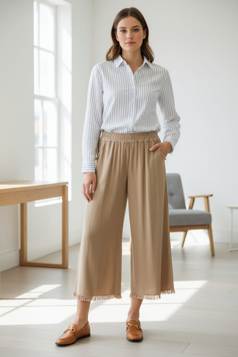 Beige wide-leg pants worn by a person on a gray background