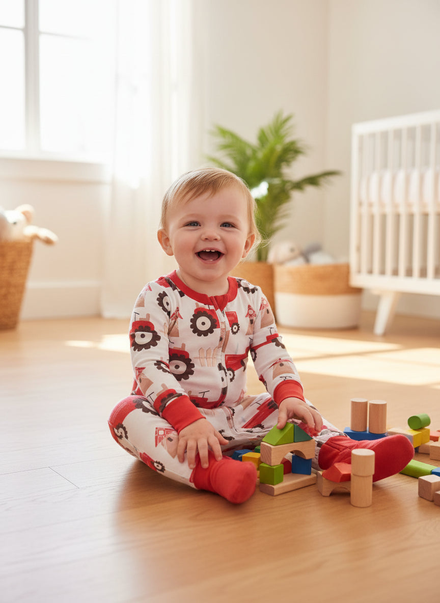 Baby onesie with red tractor pattern on a textured surface