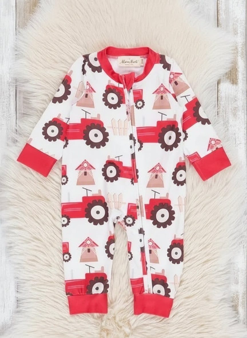 Baby onesie with red tractor pattern on a textured surface