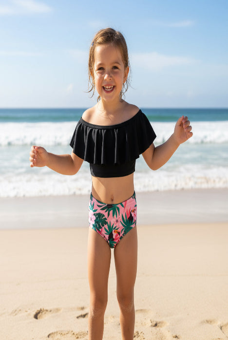 Black bikini top and pink floral bikini bottom on a hanger with a clothing store background.