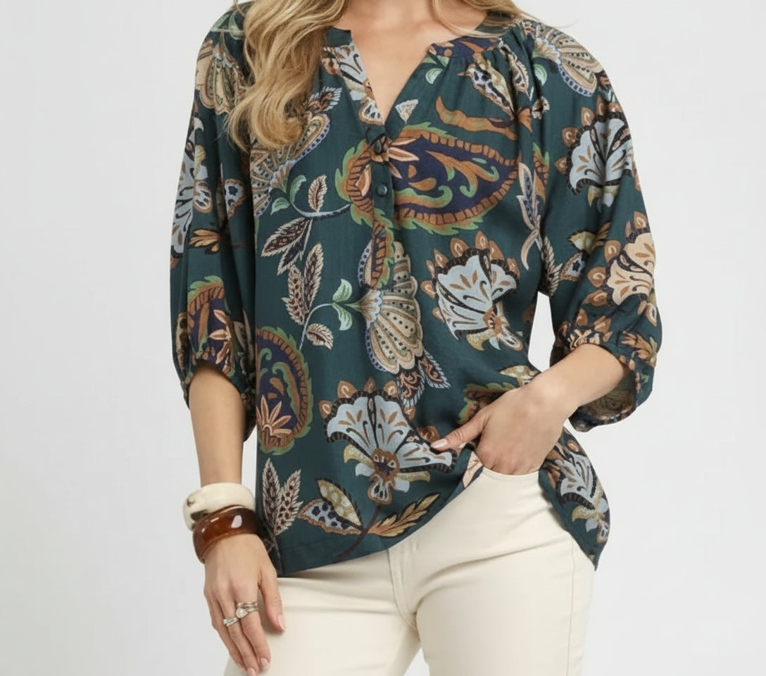 Woman wearing a patterned blouse with a plain background