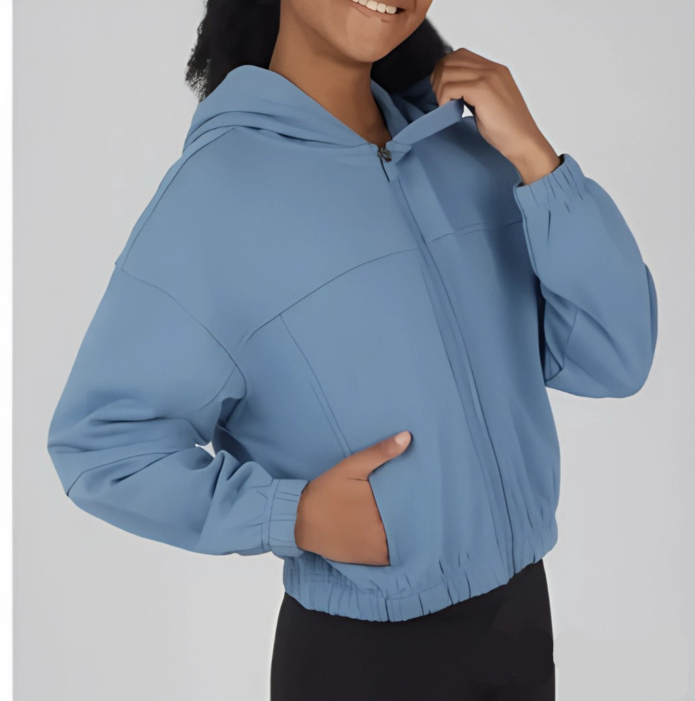 Person wearing a blue jacket with a plain background