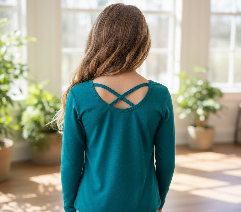 Teal long-sleeve top with cut-out design on a white background