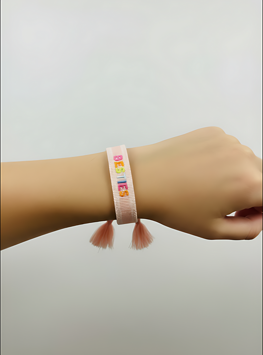 Pink bracelet with colorful beads on a wrist against a light gray background