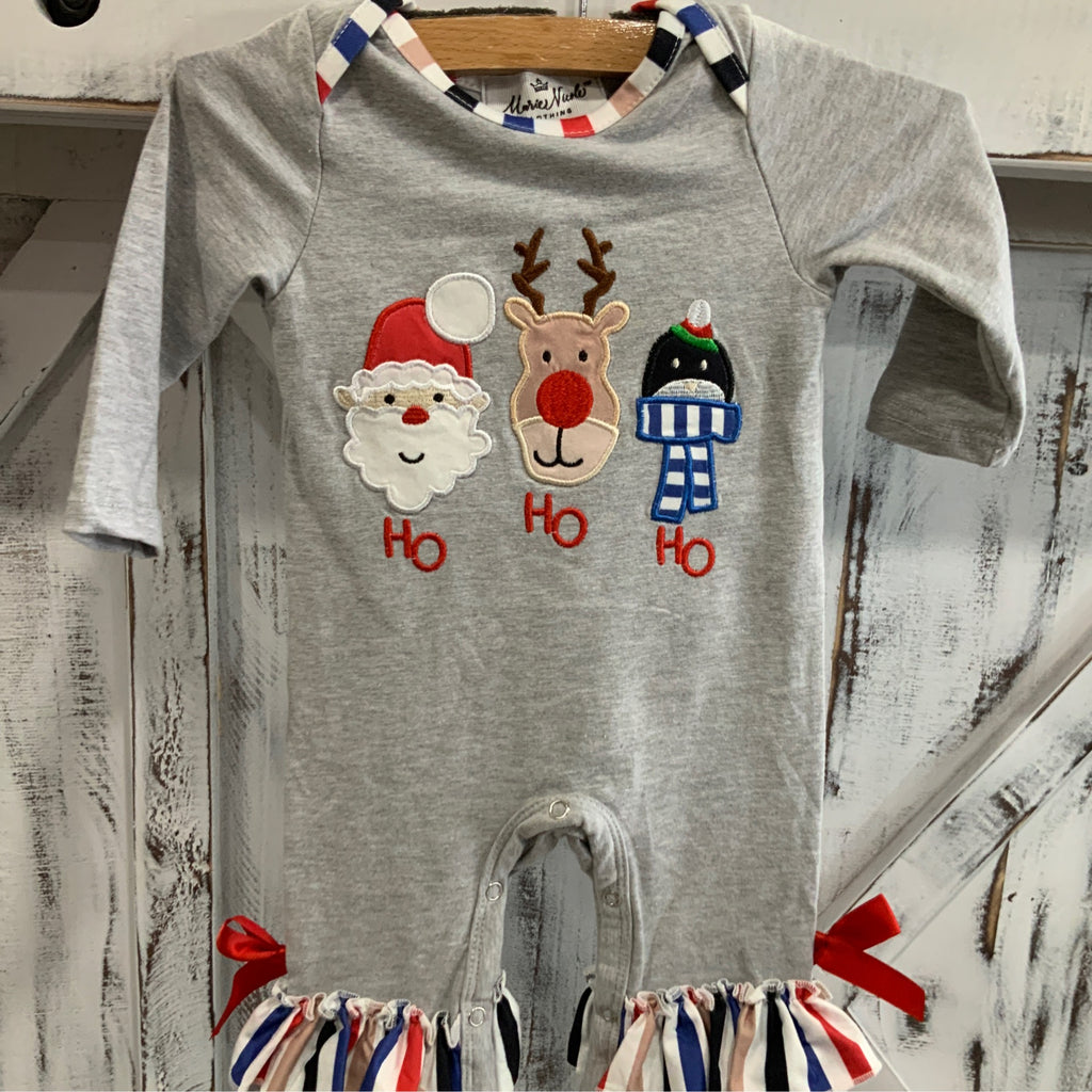 Gray baby romper with Christmas-themed appliqués on a wooden surface