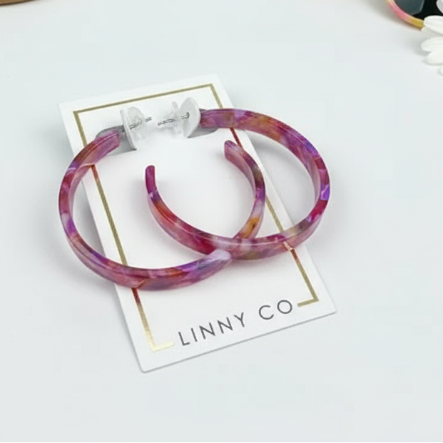 Pair of marbled hoop earrings on a LINNY CO branded card.