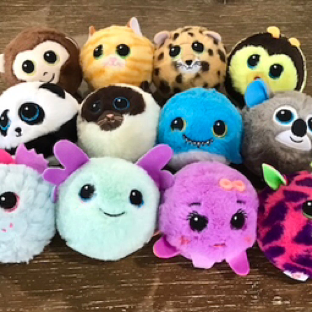 Collection of colorful plush toys on a wooden surface