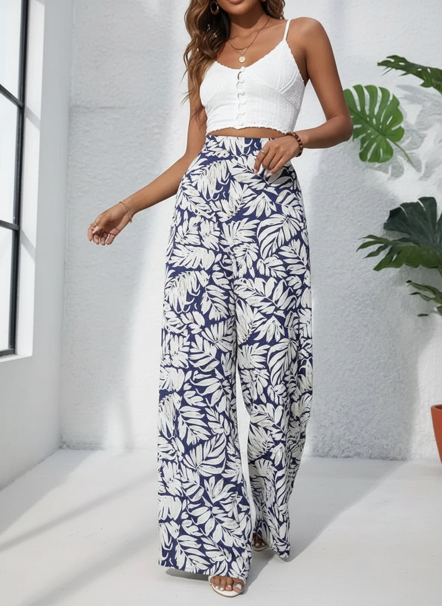 Person wearing navy and white leaf-patterned pants with a white top against a gray background.