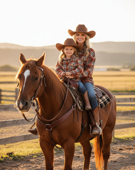 Woman and child riding a horse in a rural setting